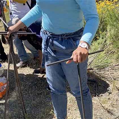 Family members use metal rods to probe for human remains. 