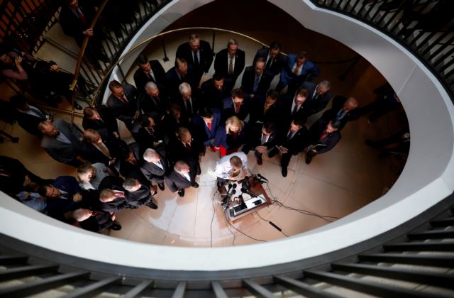 Overhead photograph of U.S. House Republicans speaking to reporters after Deputy Assistant Secretary of Defense Laura Cooper arrived to testify at a closed-door deposition as part of the U.S. House of Representatives impeachment inquiry.