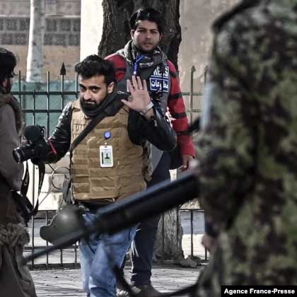  Taliban fighters walk toward journalists during a protest in Kabul on December 28, 2021. 