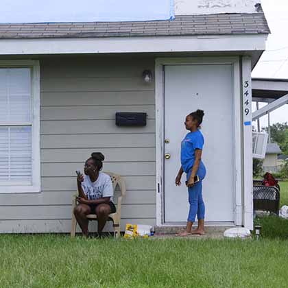Photograph of Joyce Nash and her daughter outside their home in the Greinwich Terrace neighborhood in Louisiana.
